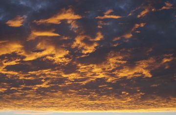 Klarer Horizont hinter orange leuchtenden Wolken
